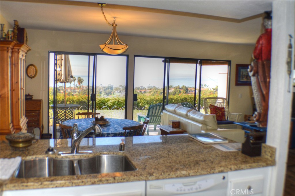 146 Avenida Baja San Clemente, CA 92672 - Photo 25 of 41 a kitchen with kitchen island a large window and living room view