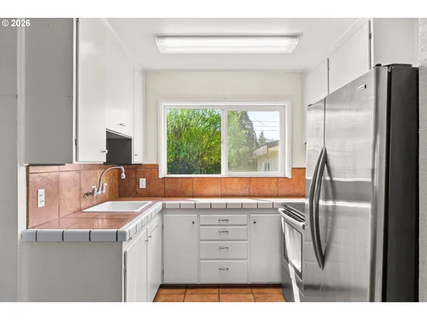 a kitchen with stainless steel appliances granite countertop a refrigerator and a sink