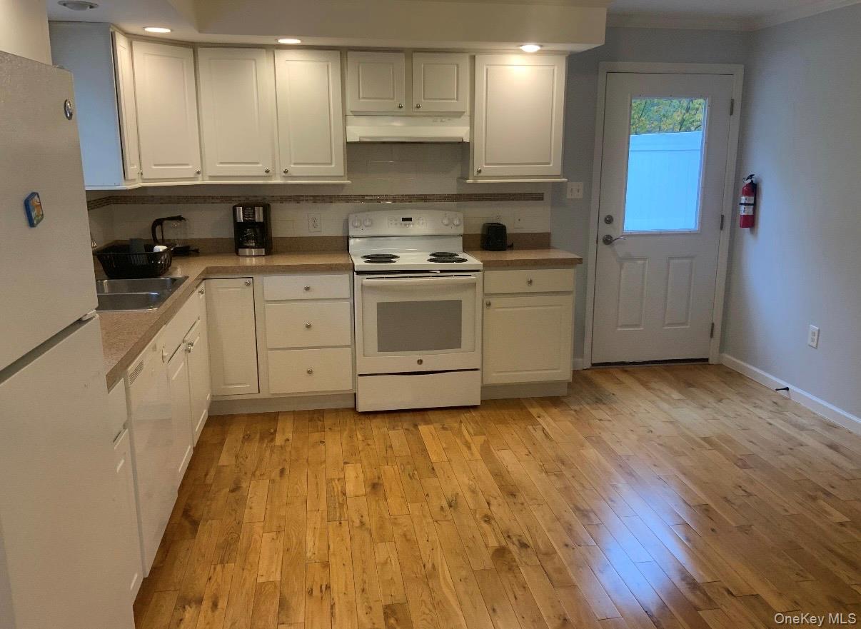 115 A High Street Peekskill, NY 10566 - Photo 6 of 17 a kitchen with wooden floors and white appliances