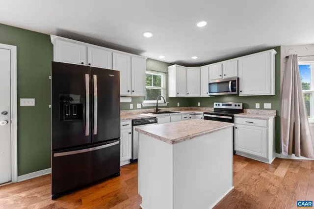 a kitchen with stainless steel appliances granite countertop a refrigerator stove microwave and sink