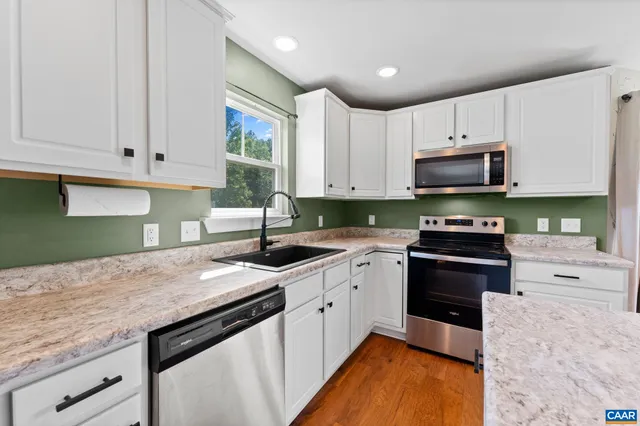 a kitchen with stainless steel appliances granite countertop a stove a sink and a granite counter tops