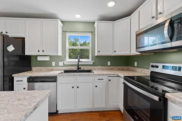 a kitchen with granite countertop a stove sink and cabinets