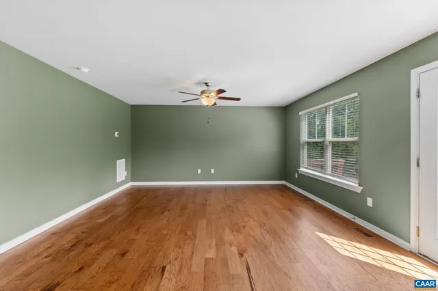 a view of a livingroom with wooden floor and a window