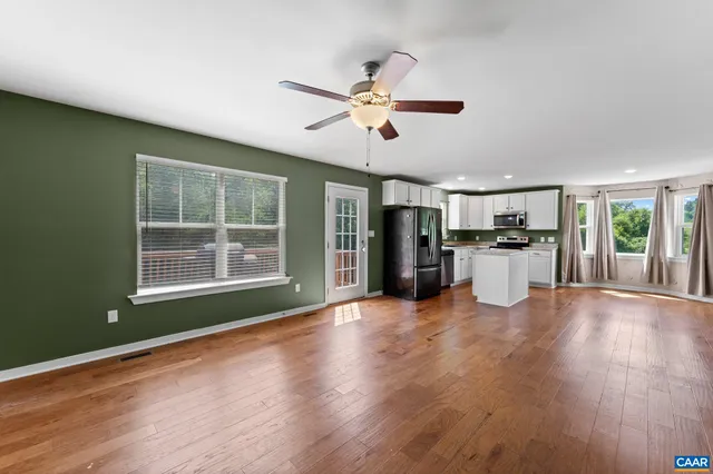 a view of a kitchen with wooden floor and a window