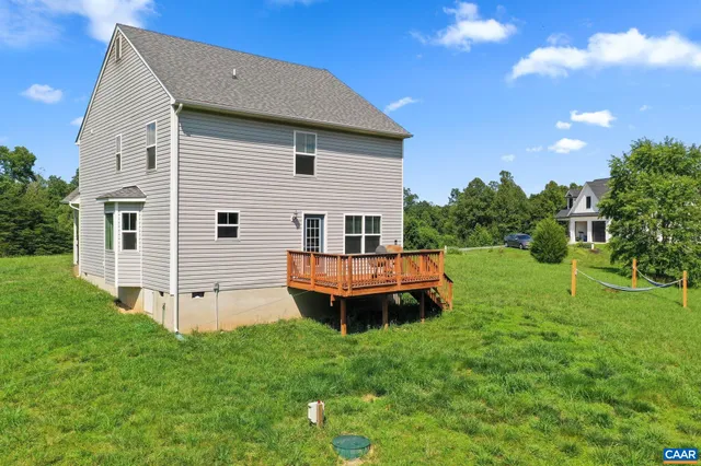 a view of a house with a backyard and a tree