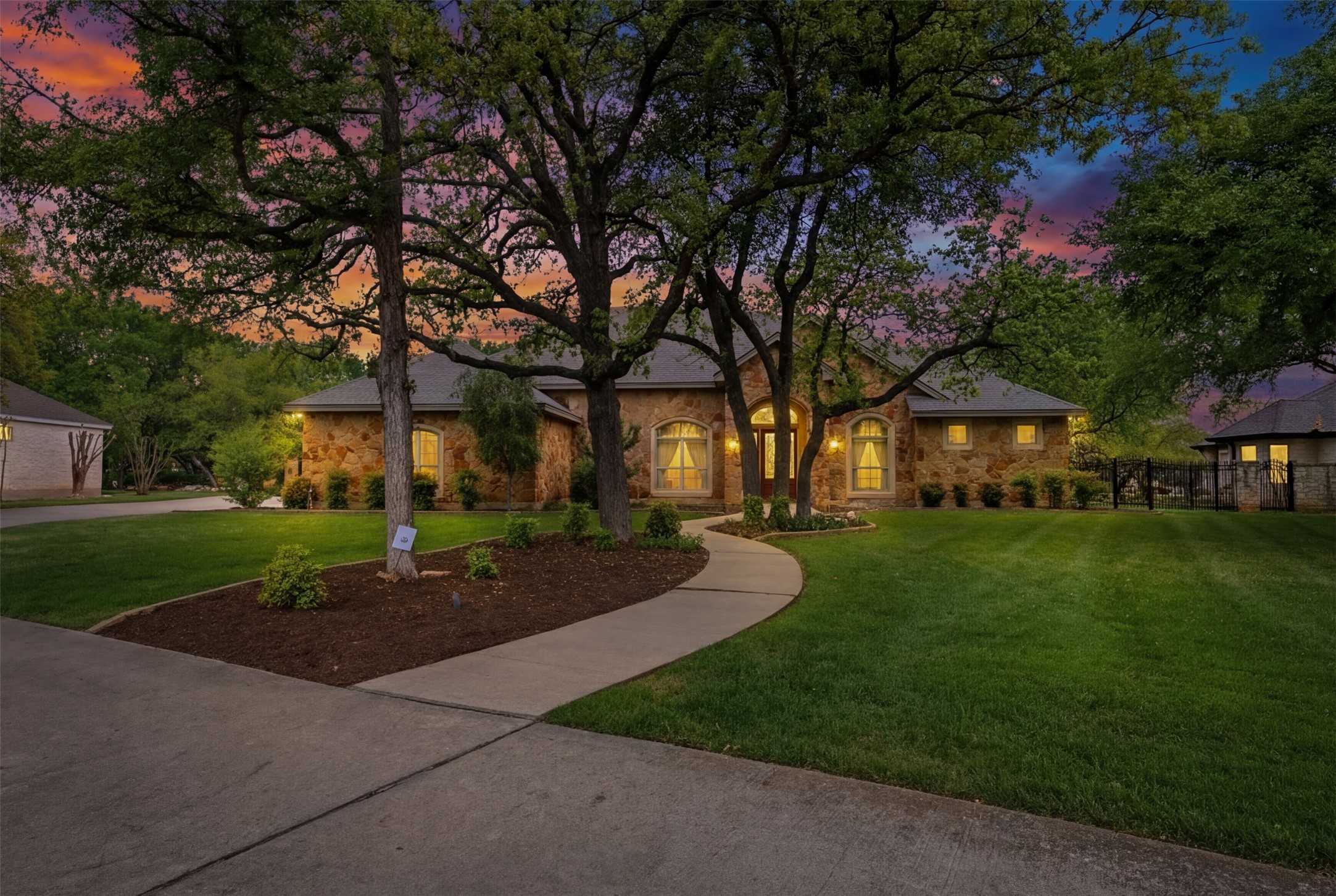 404 10 Oaks Drive Georgetown, TX 78633 - Photo 1 of 1 Twilight View of the front of the property featuring the front yard and stone siding. House also has electric uplighting!