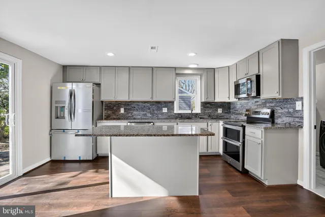 a kitchen with stainless steel appliances granite countertop a refrigerator stove microwave and sink