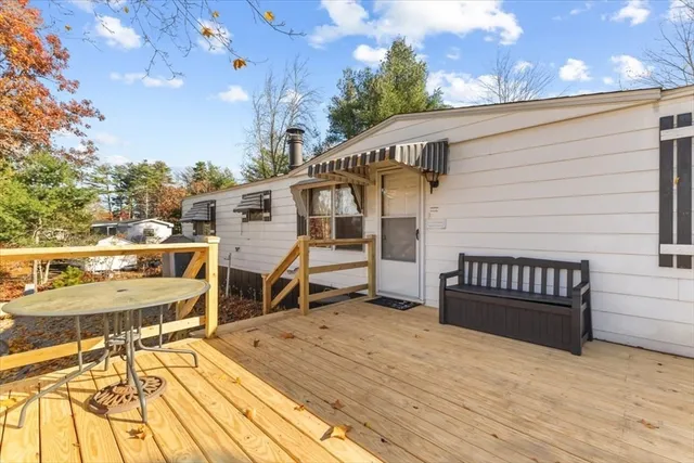a view of a house with a wooden deck and a patio