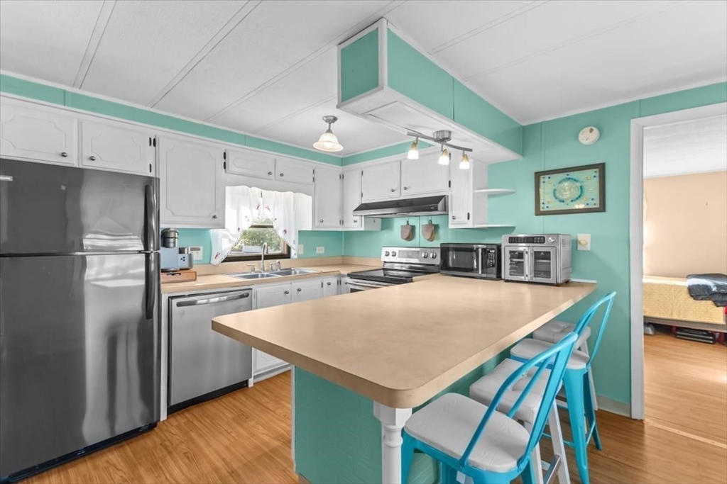 5 Presidents Way Carver, MA 02330 - Photo 5 of 30 a kitchen with kitchen island a stove a table and chairs in it