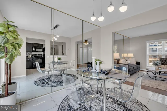 a living room with furniture kitchen view and a chandelier