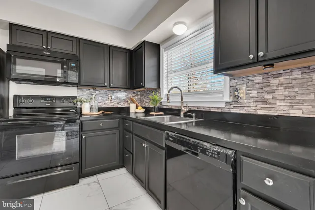 a kitchen with stainless steel appliances granite countertop a sink stove and microwave