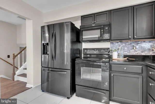 a kitchen with stainless steel appliances granite countertop a refrigerator stove and cabinets