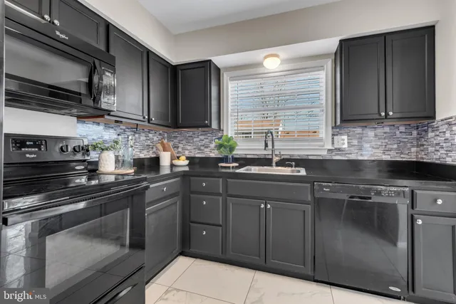a kitchen with stainless steel appliances granite countertop a sink stove and microwave