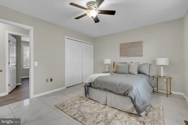 a spacious bedroom with a bed and a ceiling fan