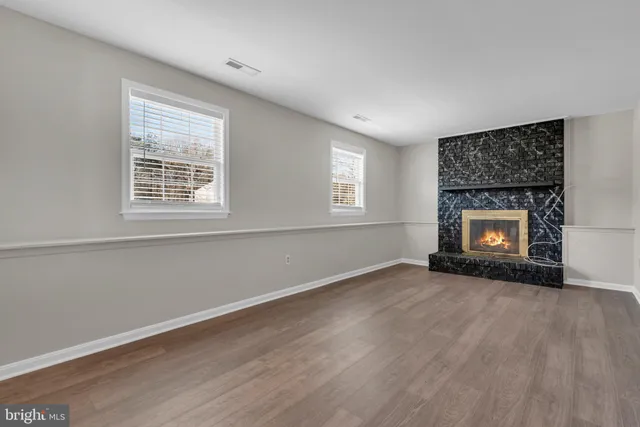 a view of an empty room with a window and fireplace