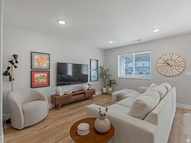 3047 Old Emigrant Road, Unit C Syracuse, UT 84075 - Photo 4 of 20 Living area with light wood-type flooring, a textured ceiling, and recessed lighting