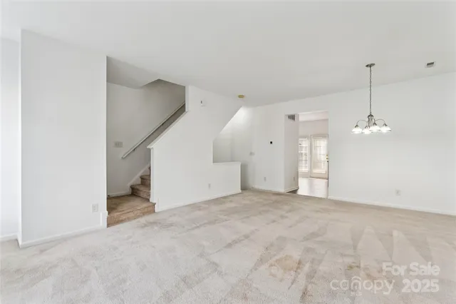 a view of a chandelier in big room and wooden floor
