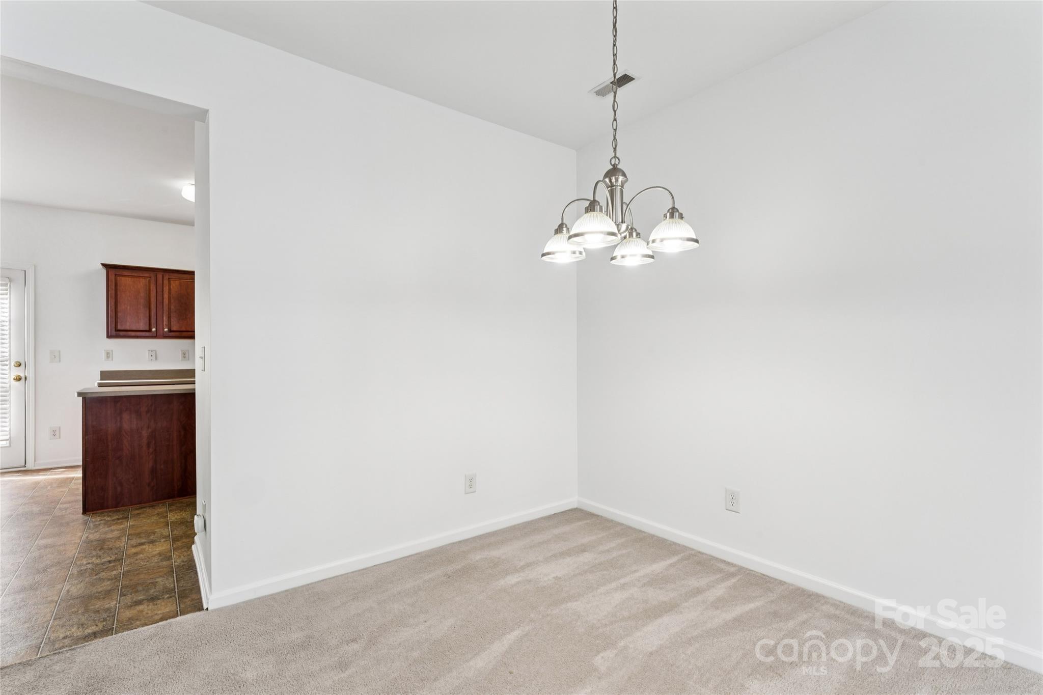 10032 Treeside Lane Matthews, NC 28105 - Photo 17 of 43 a view of a chandelier in big room and wooden floor