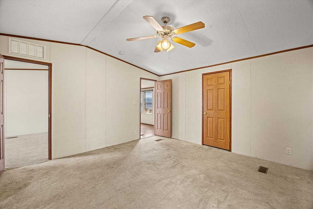 2903 Centaurus Way Granbury, TX 76048 - Photo 23 of 31 Unfurnished bedroom featuring vaulted ceiling, carpet floors, crown molding, a ceiling fan, and a decorative wall