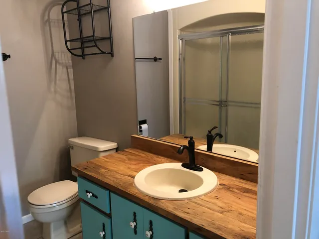 a bathroom with a granite countertop sink toilet and a mirror