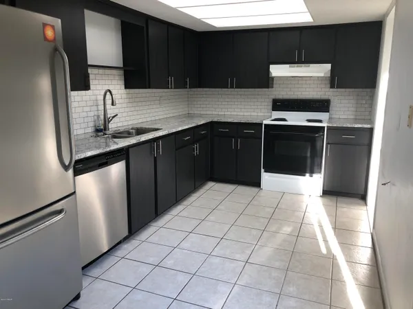 a kitchen with stainless steel appliances granite countertop a stove a sink and a microwave