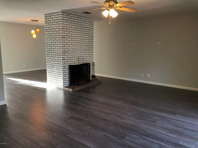 a view of a livingroom with wooden floor and a fireplace