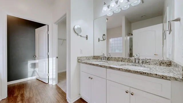 a bathroom with a granite countertop sink a mirror and a shower