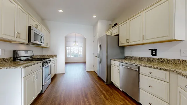 a kitchen with stainless steel appliances granite countertop a stove a sink and a refrigerator