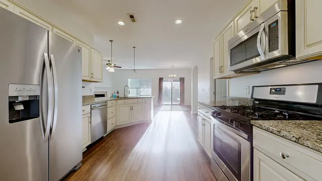 a large kitchen with stainless steel appliances granite countertop a stove a sink and a refrigerator