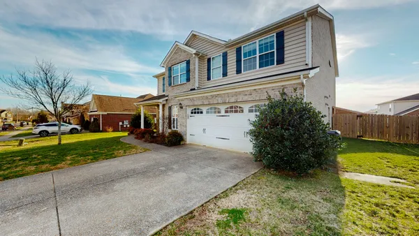 a front view of a house with a yard and garage