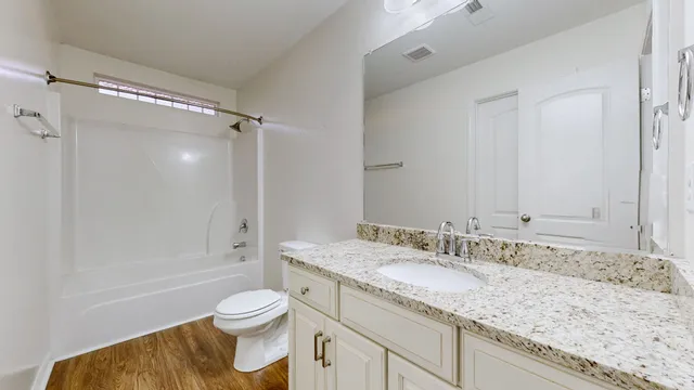 a bathroom with a granite countertop sink toilet and shower