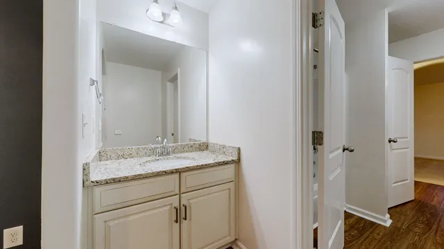 a bathroom with a granite countertop sink and a mirror