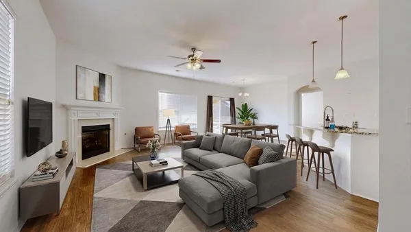 an empty room with wooden floor chandelier fan and windows