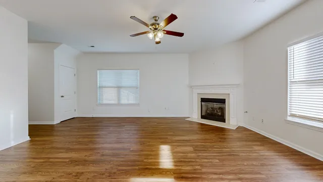 an empty room with window and fireplace