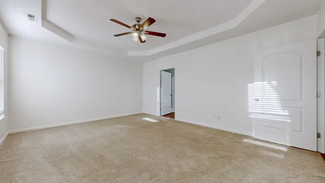 an empty room with windows and fan view