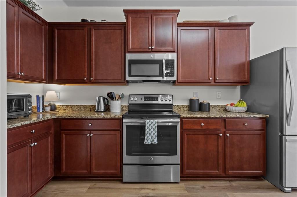 369 Franklin Lane Acworth, GA 30102 - Photo 9 of 27 a kitchen with stainless steel appliances granite countertop wooden cabinets a stove top oven a sink and dishwasher