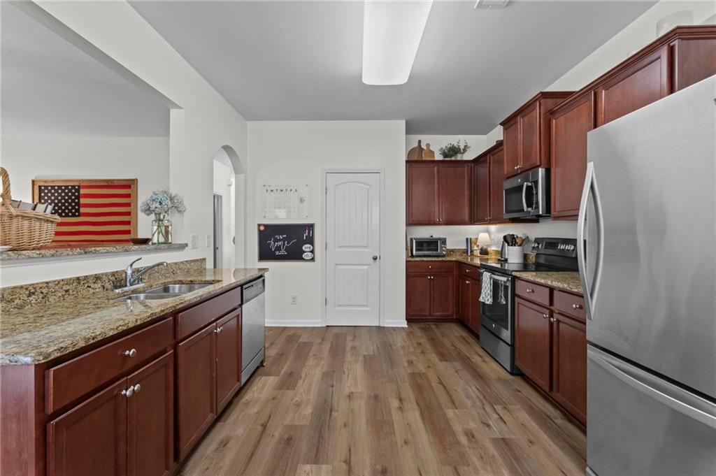 369 Franklin Lane Acworth, GA 30102 - Photo 10 of 27 a kitchen with stainless steel appliances granite countertop a refrigerator a stove top oven a sink dishwasher and wooden floor