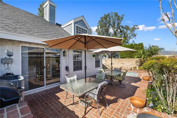 a view of a patio with a table and chairs under an umbrella