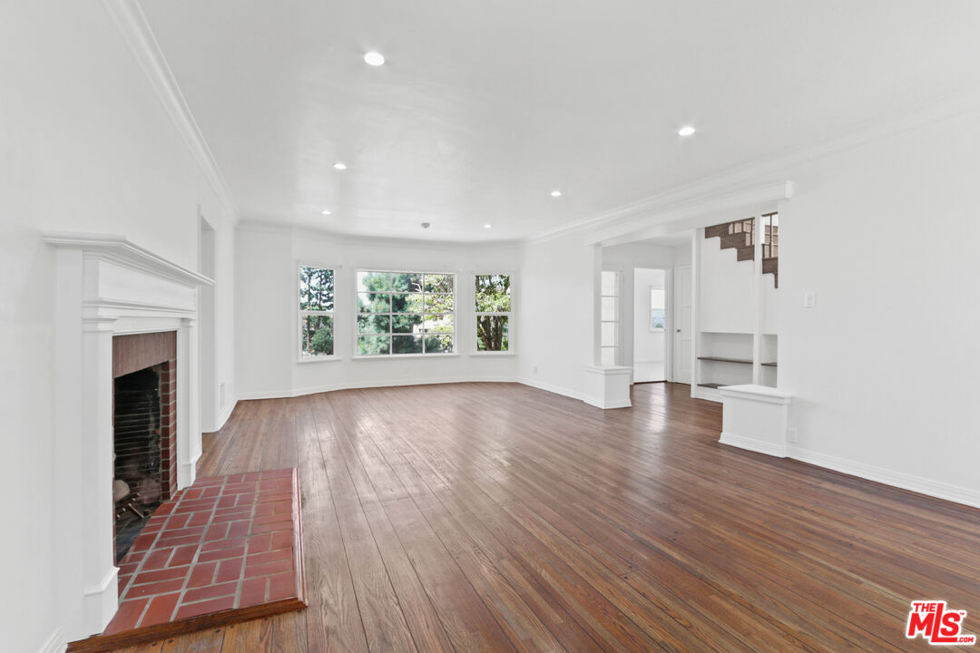 3851 Olympiad Drive View Park, CA 90043 - Photo 12 of 35 an empty room with wooden floor and a fireplace