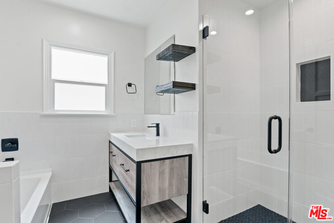 3851 Olympiad Drive View Park, CA 90043 - Photo 14 of 35 a bathroom with a sink a mirror and shower