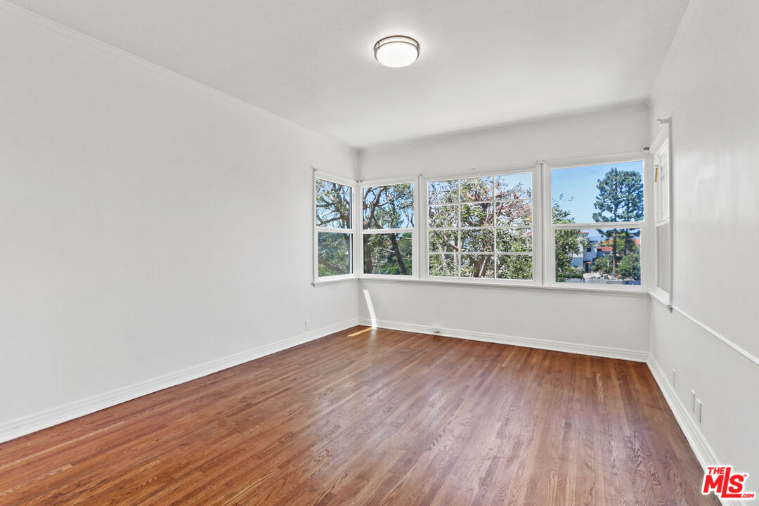 3851 Olympiad Drive View Park, CA 90043 - Photo 16 of 35 an empty room with wooden floor and windows