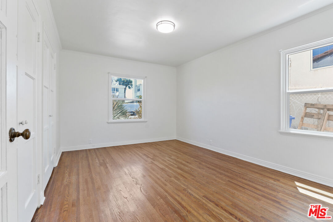 3851 Olympiad Drive View Park, CA 90043 - Photo 18 of 35 an empty room with wooden floor and windows