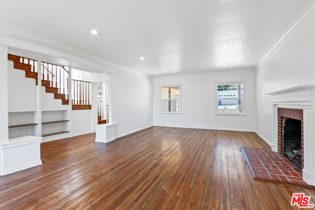 3851 Olympiad Drive View Park, CA 90043 - Photo 20 of 35 an empty room with wooden floor and fireplace