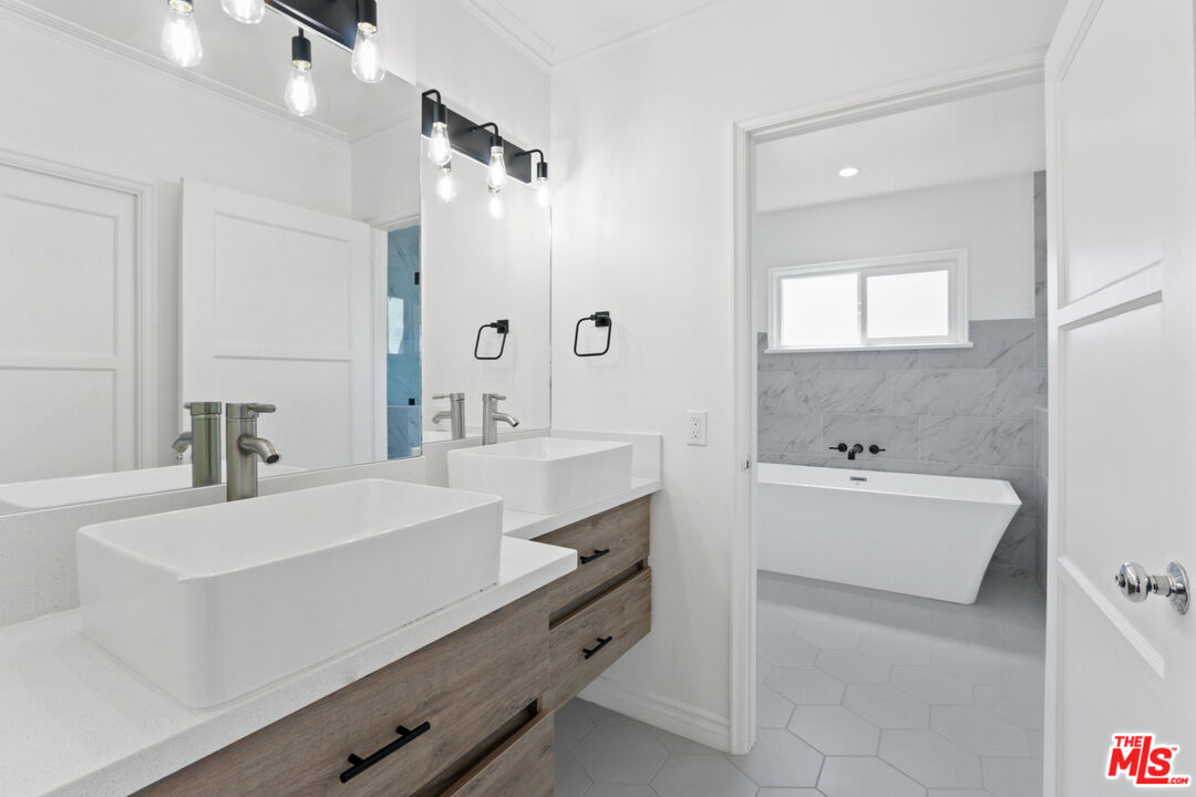 3851 Olympiad Drive View Park, CA 90043 - Photo 28 of 35 a bathroom with a sink tub double vanity and mirror