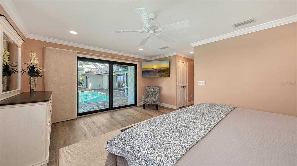 595 Bowsprit Lane Longboat Key, FL 34228 - Photo 13 of 31 a view of a bedroom with wooden floor and a large window