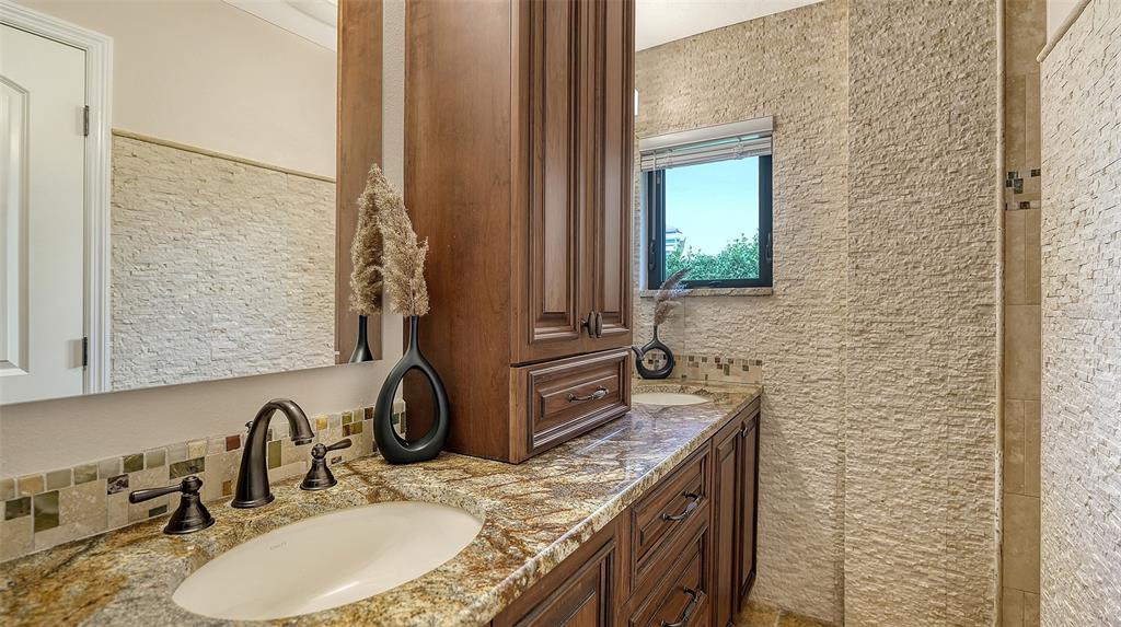 595 Bowsprit Lane Longboat Key, FL 34228 - Photo 18 of 31 a bathroom with a granite countertop sink a mirror and vanity