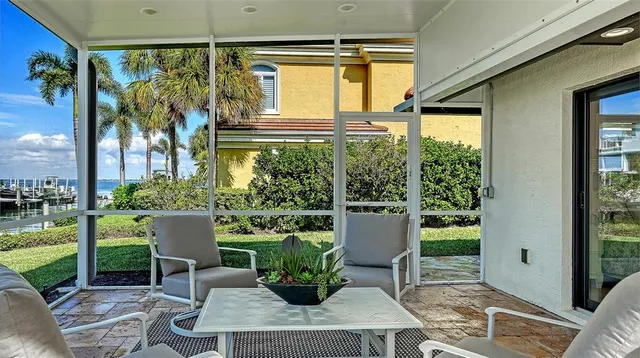 a view of a porch with chairs and potted plants