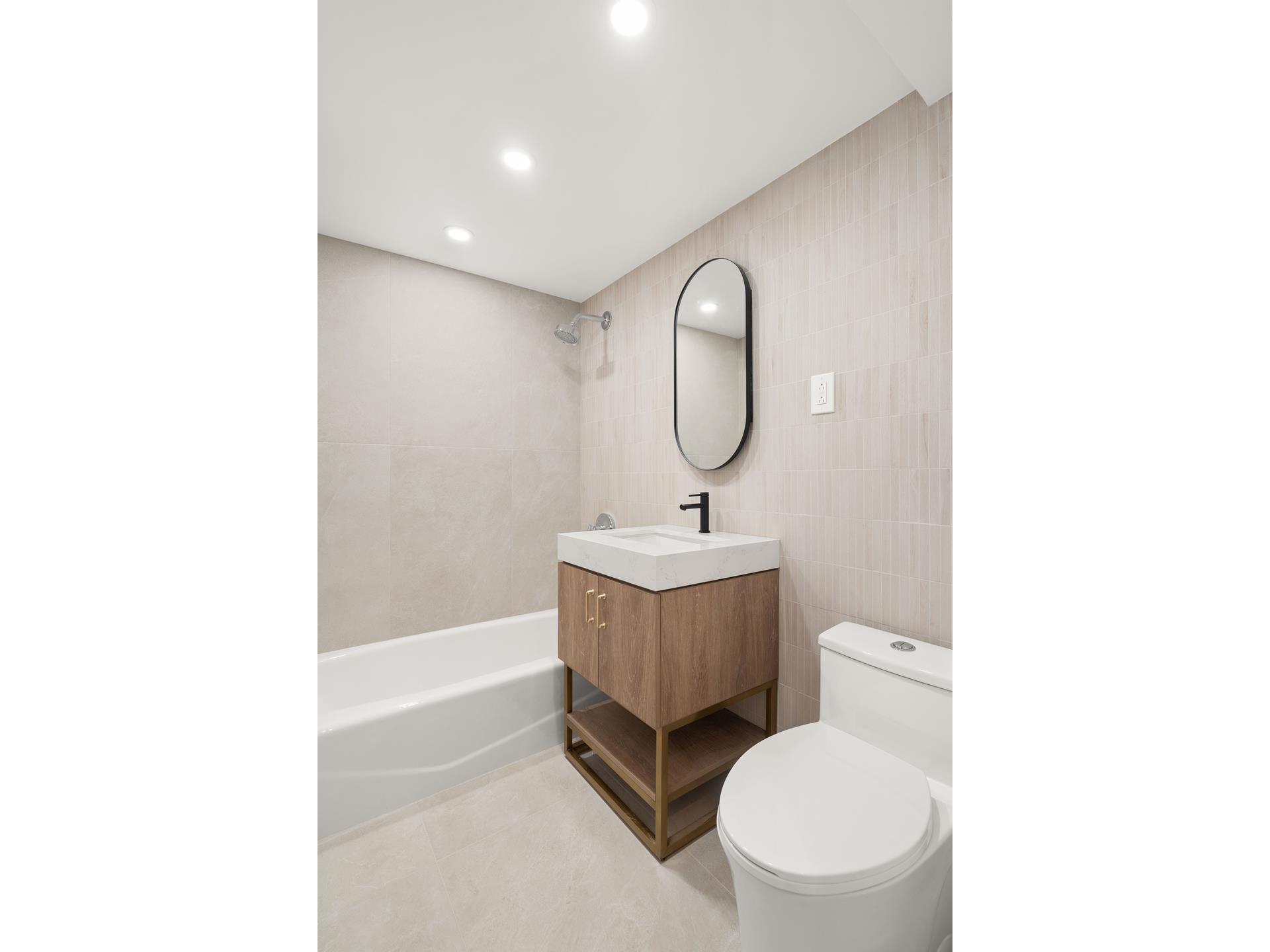 321 East 48th Street, Unit 11H Manhattan, NY 10017 - Photo 7 of 8 a bathroom with a toilet a sink and mirror