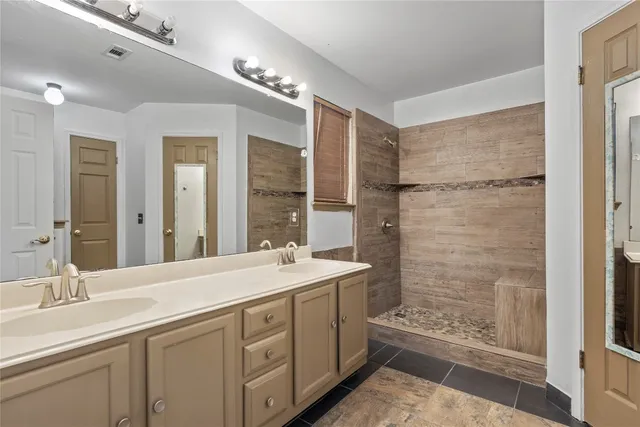 a spacious bathroom with double sink and a mirror