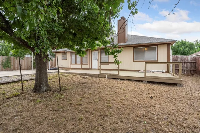 a backyard of a house with wooden floor and fence